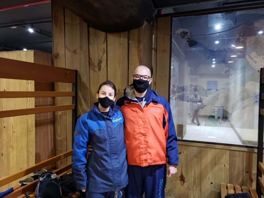 Rafa e Lê na plataforma vestindo a roupa para entrar na neve